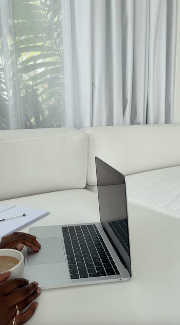 Laptop open on a white sofa