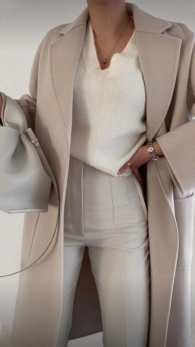 Person in neutral tailoring with a long camel coat