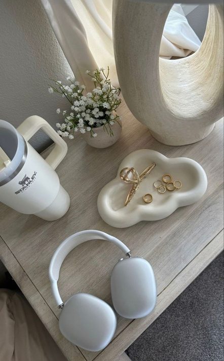 Side table with headphones, a water bottle and a small vase of flowers